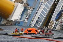 Firefighters tow an abandoned life raft from the capsized cruise liner Costa Concordia off the west coast of Italy at Giglio island