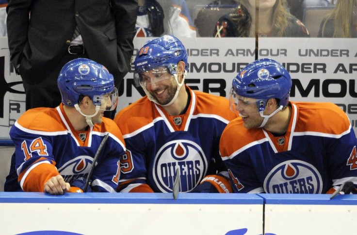Sam Gagner (C) talks with linemates Jordan Eberle (L) and Taylor Hall on the bench after scoring his fourth goal against the Chicago Blackhawks.