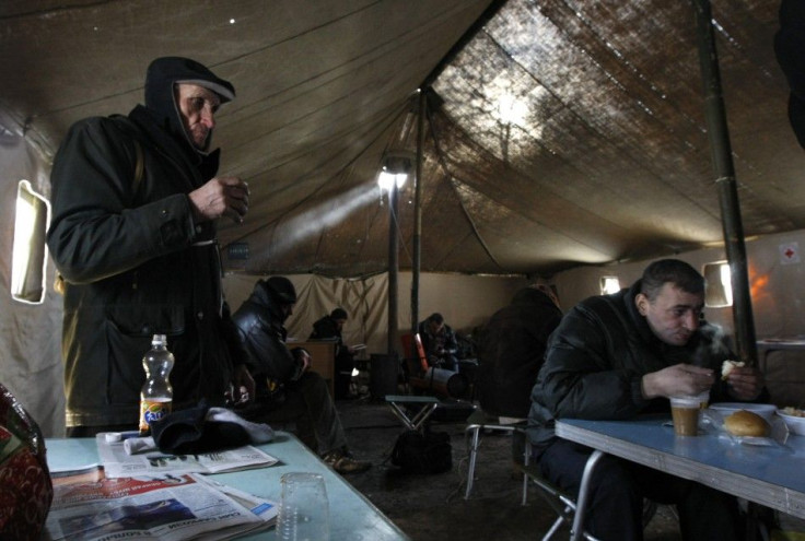 Homeless people have a hot meal provided by local authorities as they warm up at a tent camp set up to provide shelter against cold weather in Kiev