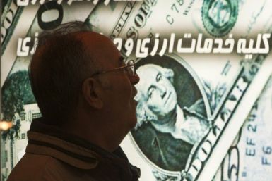 An Iranian man walks past a currency exchange shop in northern Tehran January 3, 2012.