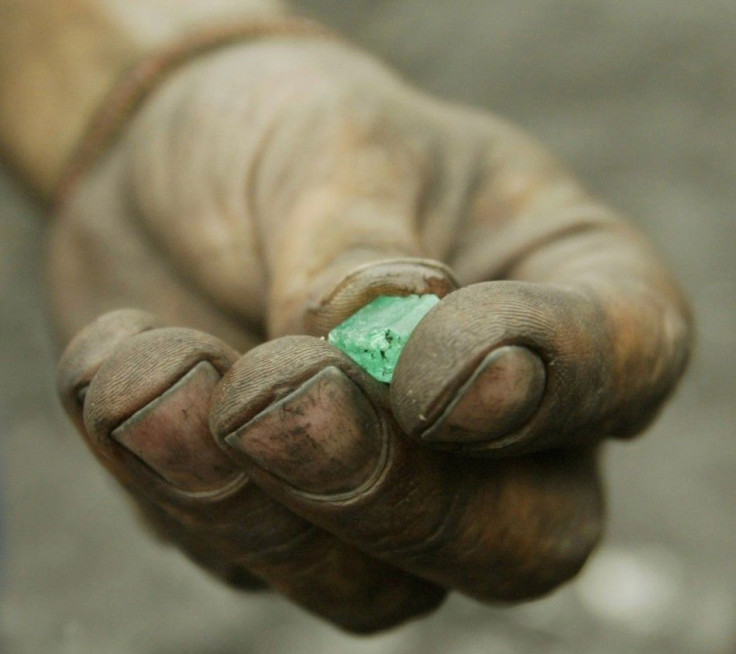 A COLOMBIAN MINER SHOWS A RAW EMERALD IN MUZU.