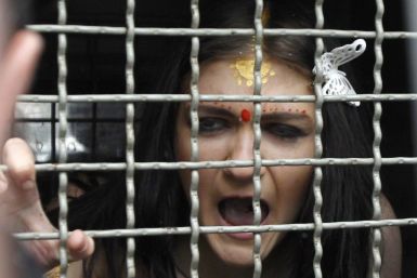 A detained activist from women&#039;s rights group Femen shouts from a police van during a protest in front of the residence of the Indian ambassador in Kiev