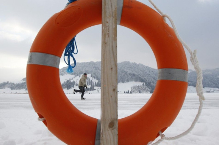 A man skates on the frozen lake Sihl (Sihlsee) past a life buoy on a freezing cold afternoon, outside Euthal, near Einsiedeln, February 4, 2012.