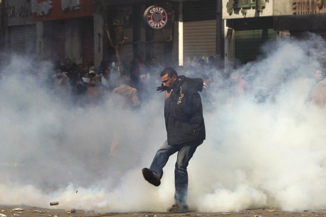 A protester kicks a tear gas canister during clashes with security forces near the Interior Ministry in Cairo February 4, 2012.