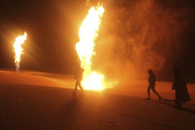People look at flames rising from blown pipelines at al-Sabeel, in the western al-Arish city in Sinai November 28, 2011.
