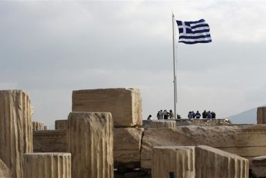 A Greek national flag flies at the archaeological site of the Acropolis Hill in Athens