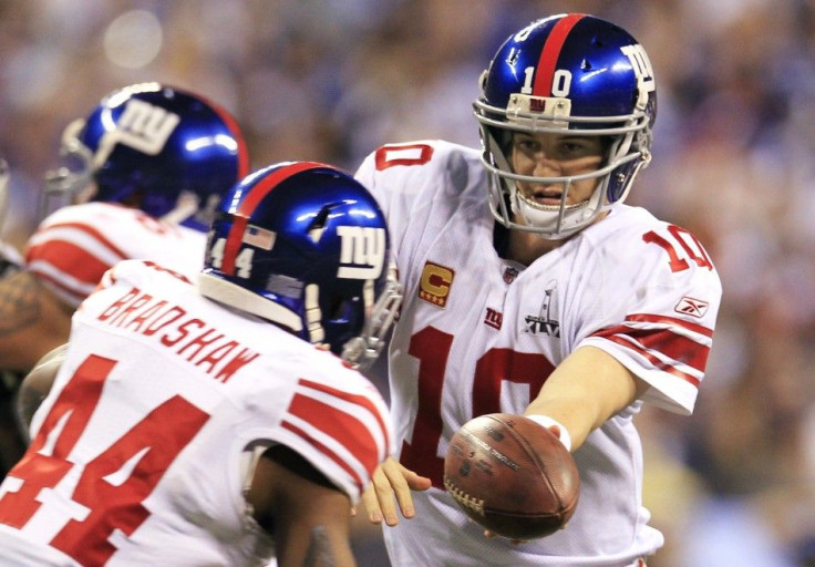 New York Giants quarterback Eli Manning (R) hands off to running back Ahmad Bradshaw during first quarter play against the New England Patriots in the NFL Super Bowl XLVI football game in Indianapolis, Indiana