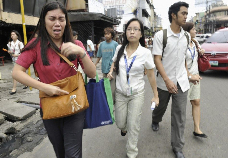 A woman cries after experiencing the earthquake along a main street of Honkera, Cebuy city