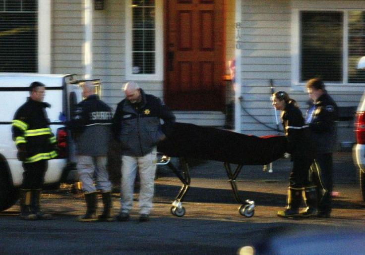 Law enforcement authorities load a body onto a vehicle following an explosion at a house in Graham