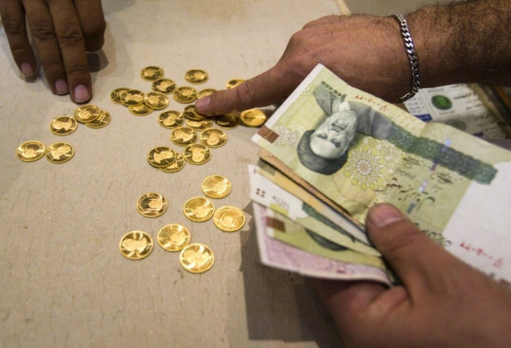 A customer buys Iranian gold coins at a currency exchange office in Tehran