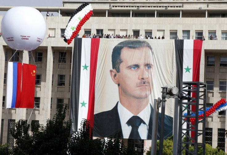 A Russian and a Chinese flag hang from a balloon during a rally of supporters of Syrian President Bashar al-Assad at al-Sabaa Bahrat square in Damascus