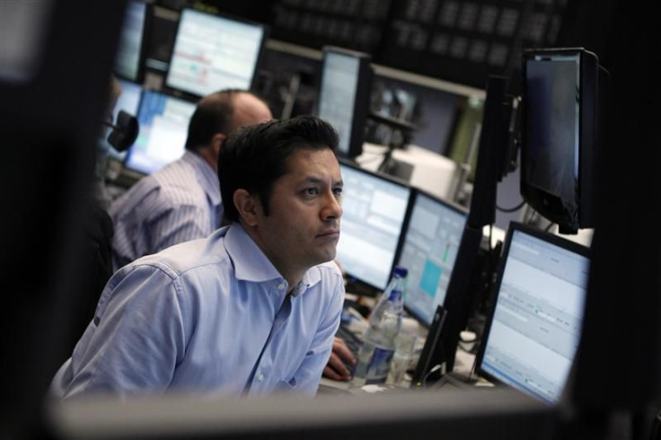 Traders work at their desks at the Frankfurt stock exchange