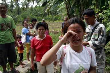 A teenager cries while waiting to be evacuated with other survivors after an earthquake along a highway in La Libertad