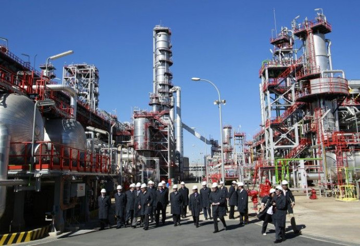 Spain's King Juan Carlos walks with members of Cepsa during his visit to a Cepsa refinery in Palos de la Frontera