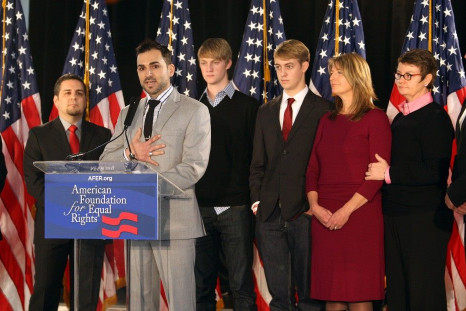 Paul Katami addresses a news conference as his partner Jeff Zarillo (L), and Kris Perry and her partner Sandy Stier (R) look on with their sons Elliot Perry and Spencer Perry (center R) after the United States Court of Appeals for the Ninth Circuit declar