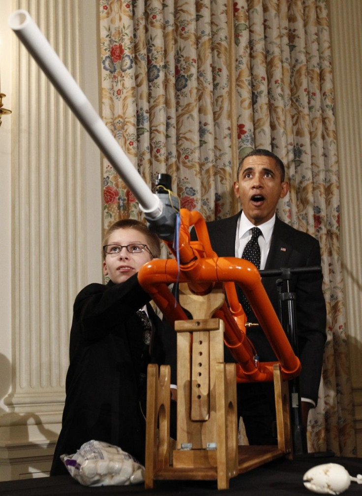 U.S. President Barack Obama reacts as Joey Hudy of Phoenix, Arizona, launches a marshmallow from his Extreme Marshmallow Cannon in the State Dining Room of the White House during the second White House Science Fair in Washington