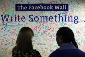People look at the Facebook wall at their office in New York