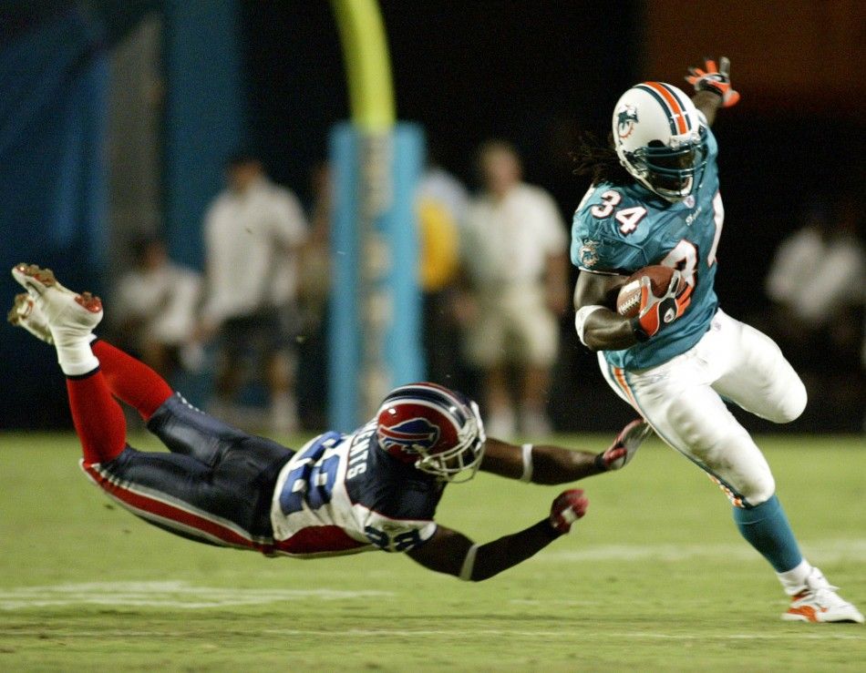 Miami Dolphins running back Ricky Williams R eludes the tackle of Buffalo Bills defender Nate Clements at Pro Player Stadium in Miami, Florida