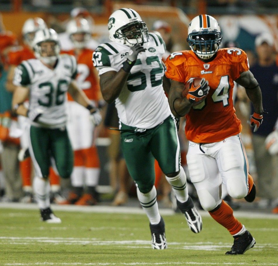 Miami Dolphins Ricky Williams R breaks away from New York Jets David Harris during the first quarter in their NFL football game in Miami, Florida 