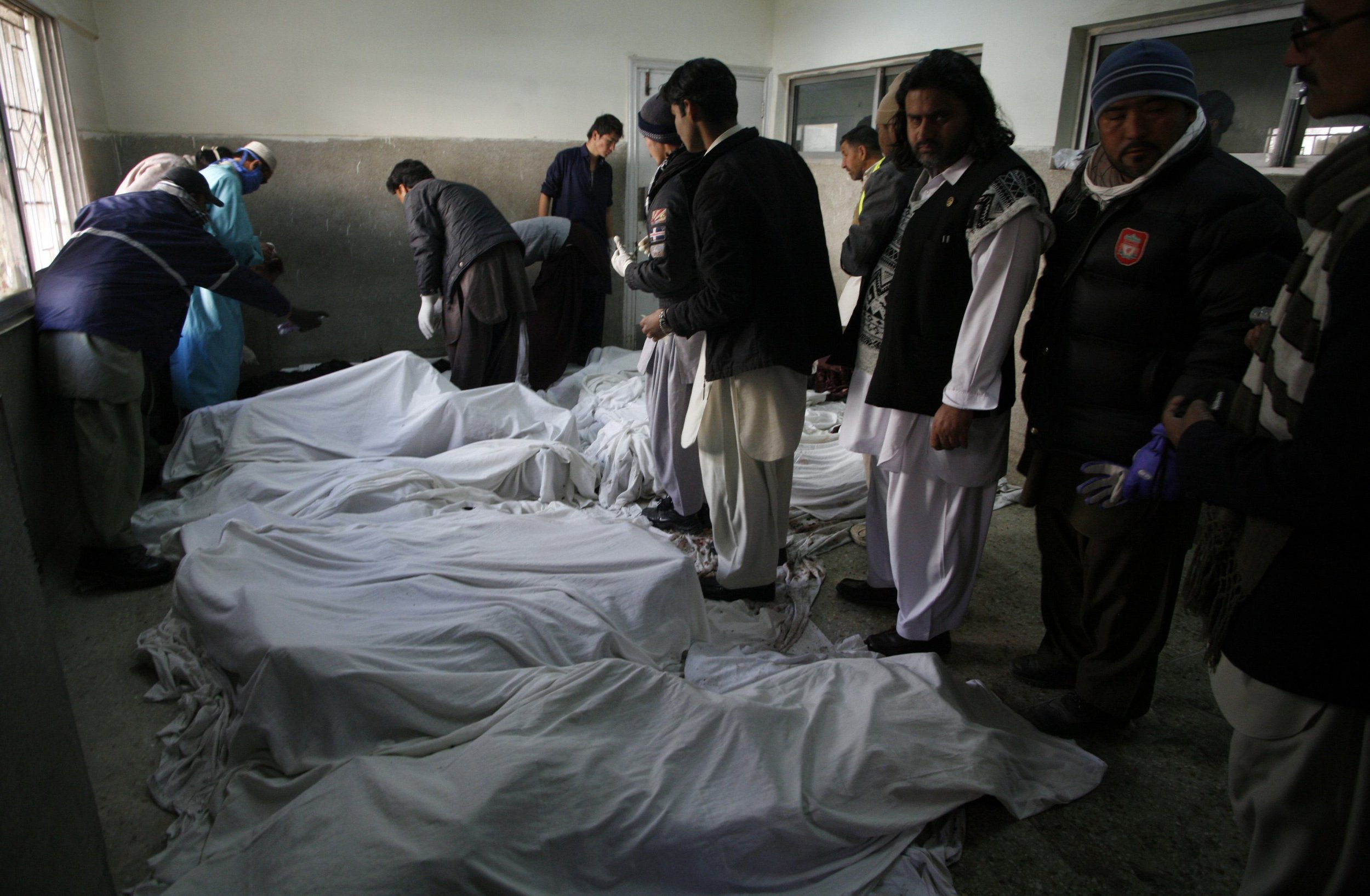 Paramedics inspect the bodies of Shia Muslim pilgrims killed by a car bomb in Quetta