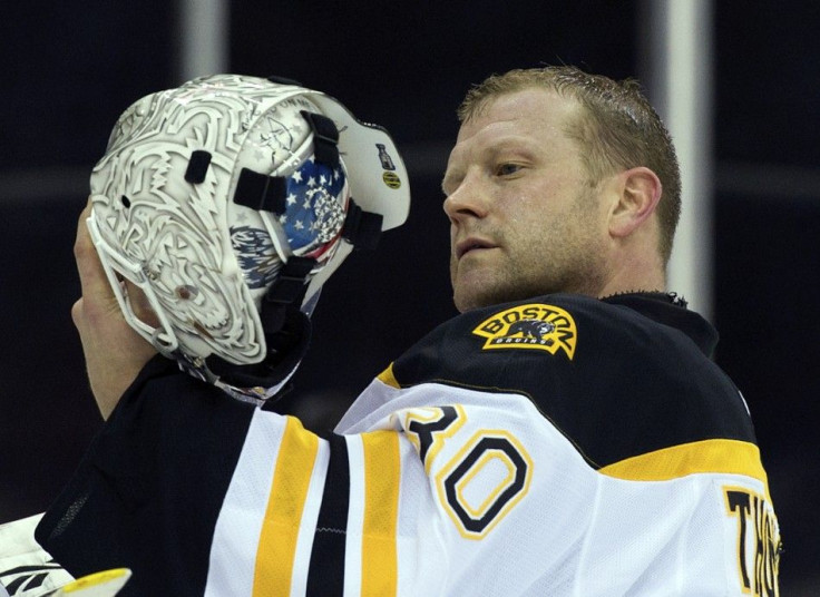 Tim Thomas examines his helmet which has some Tea Party symbols painted on it.