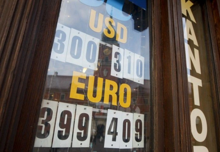 The currency exchange rates are displayed at an exchange office with the Royal Castle reflected in the window in Warsaw