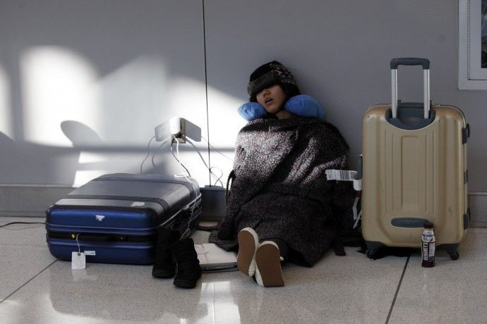A passenger sleeps at JFK International Airport as she waits for the airport to reopen in New York