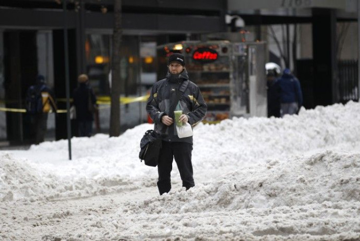Man waits to cross snow-covered portion of Broadway in New York's Times Square