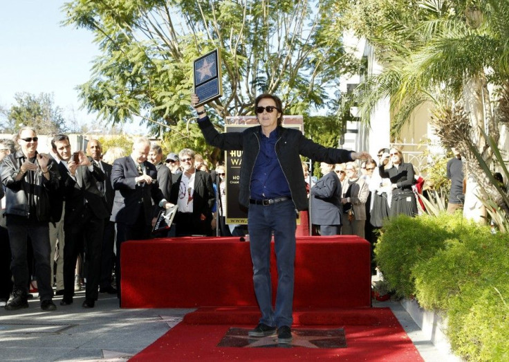 British singer Paul McCartney poses on his star after it was unveiled on the Walk of Fame in Hollywood, California
