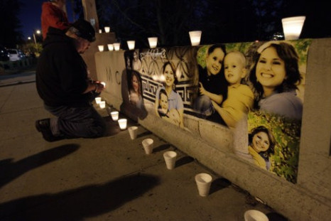 Ken Landgrebe lights a candle next to photographs of Susan Cox Powell and her sons Braden and Charlie,