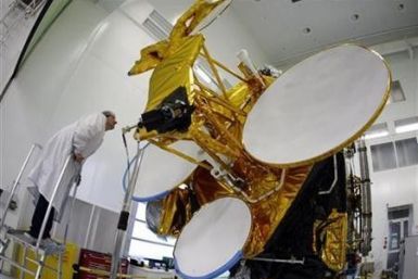 A technician checks a communications satellite during a press visit at Thales Alenia Space in southeastern France, October 7, 2009.