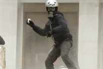 A protester hurls rocks at riot police in Athens Friday