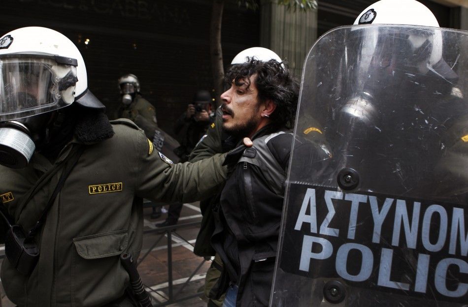 Police detain a protester during demonstrations in Athens Friday