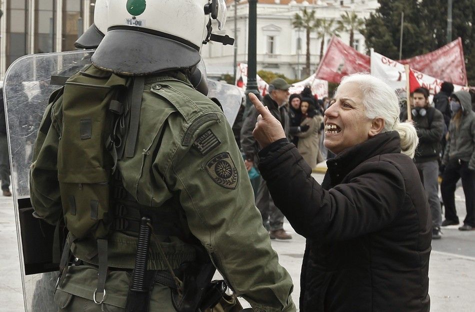 A woman confronts a riot police office during demonstrations in Athens Friday