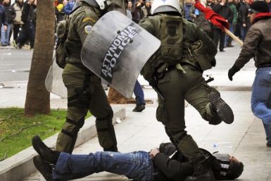 A riot policeman kicks a protester during clashes in Athens