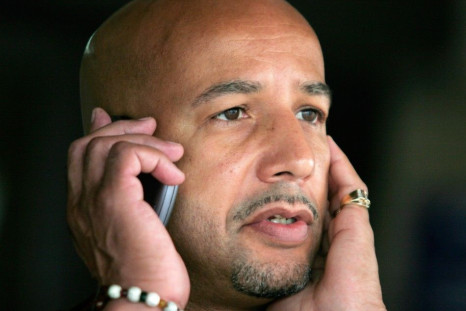 Mayor Ray Nagin talks on a mobile phone as he waits for rain to subside at an event commemorating the upcoming anniversary of Hurricane Katrina at the Superdome in New Orleans, Louisiana, August 26, 2006.