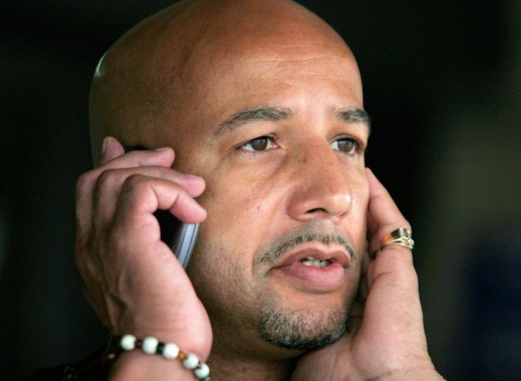 Mayor Ray Nagin talks on a mobile phone as he waits for rain to subside at an event commemorating the upcoming anniversary of Hurricane Katrina at the Superdome in New Orleans, Louisiana, August 26, 2006.