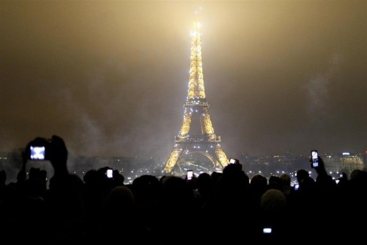 Revellers take snapshots of the Eiffel tower 