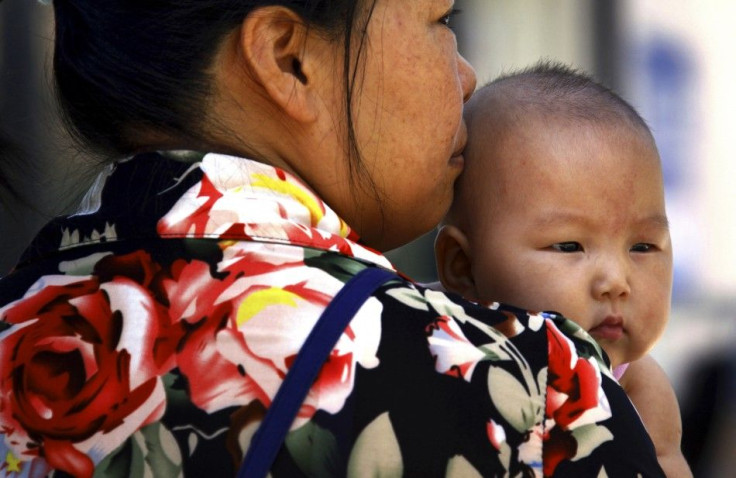 A mother holds her baby outside a children&#039;s hospital in central Beijing