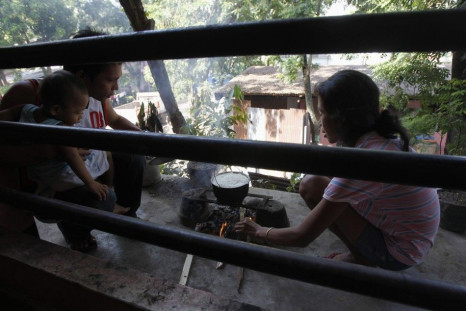 A couple cooks a pot of rice in a school building used as an evacuation center for tropical storm Washi survivors