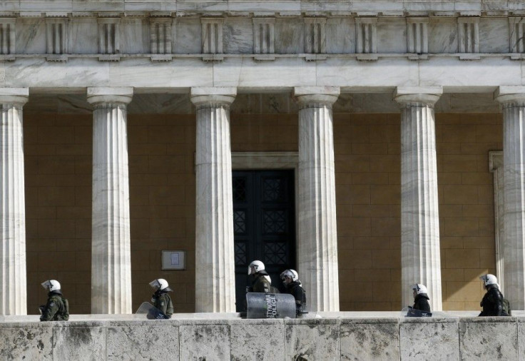 Riot policemen walk in front of the parliament during an anti-austerity rally in Athens February 11, 2012.