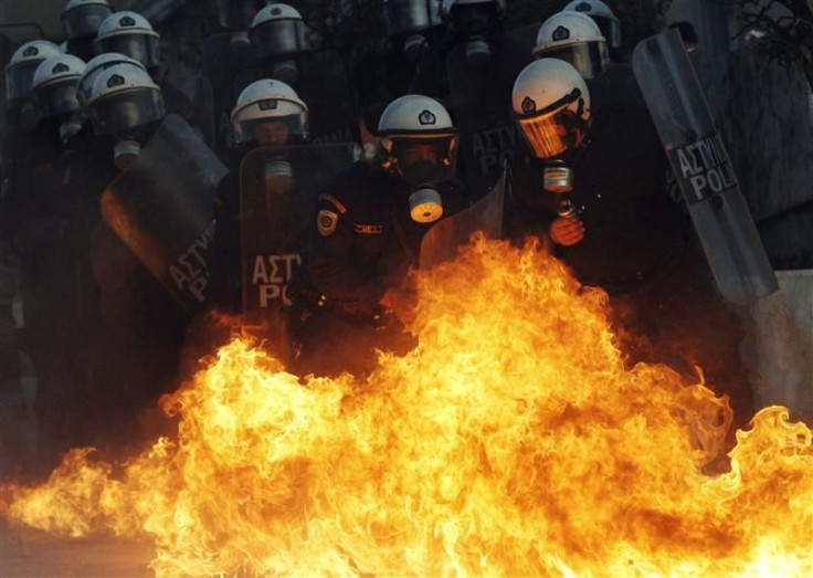 A petrol bomb explodes near riot police during an anti-austerity demonstration in Athens