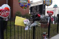 Flowers and a card are seen at a makeshift memorial in front of The New Hope Baptist Church in Newark