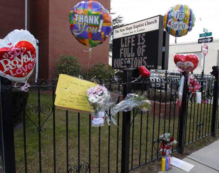 Flowers and a card are seen at a makeshift memorial in front of The New Hope Baptist Church in Newark