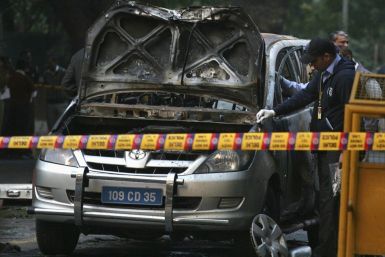 Police and forensic officials examine damaged car at Israeli Embassy after explosion in New Delhi