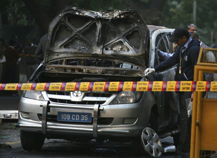 Police and forensic officials examine damaged car at Israeli Embassy after explosion in New Delhi