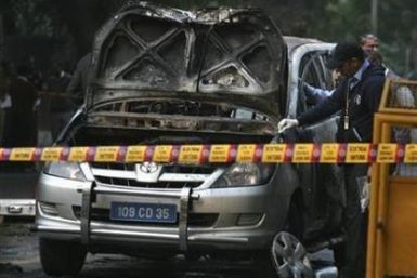 Police and forensic officials examine a damaged Israeli embassy car after an explosion in New Delhi February 13, 2012.