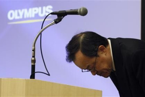 Olympus Corp President Shuichi Takayama bows after speaking at a news conference in Tokyo February 13, 2012. Japan&#039;s scandal-hit Olympus Corp on Monday forecast a $410 million full-year net loss due to its ailing camera business and tax asset writedo