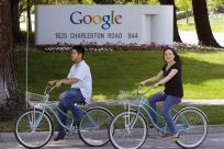 People ride their bikes past Google Inc. headquarters in Mountain View